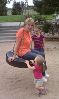 My girls pushing their grandma on the tire swing. 